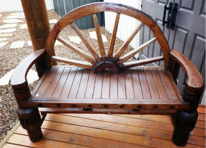 Удобная скамейка выполнена с элементом колеса украсит любое крыльцо около дома.