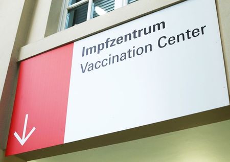 A sign leading the way towards a vaccination centre at the Festhalle is pictured as the coronavirus disease (COVID-19) outbreak continues in Frankfurt, Germany December 17, 2020. REUTERS/Ralph Orlowski?