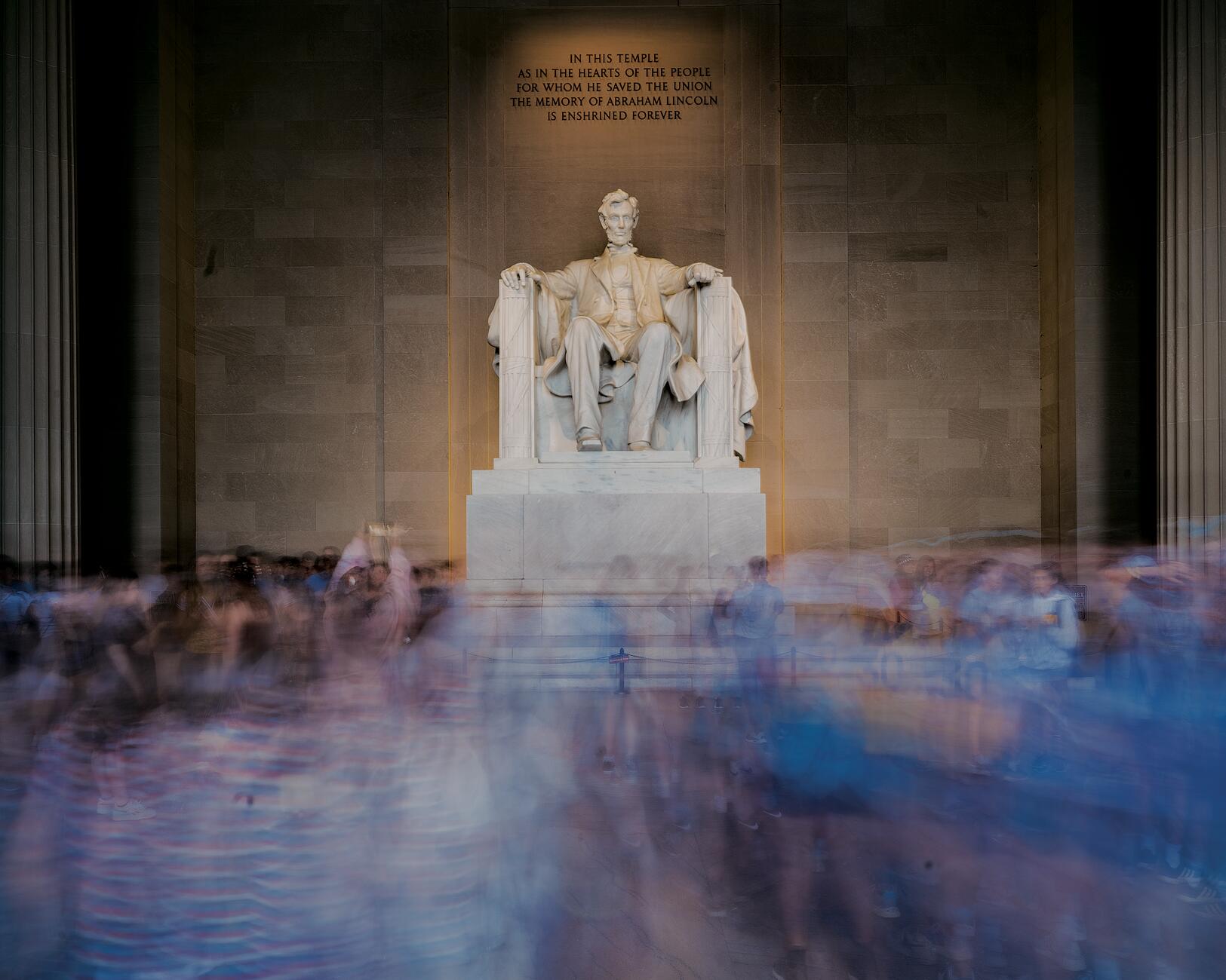 Picture of the statue of Abraham Lincoln in Washington DC with a crowd of people below him moving around