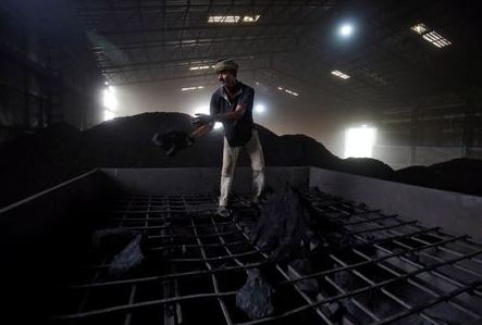A labourer works inside a coal yard on the outskirts of Ahmedabad, India, April 6, 2017. REUTERS/Amit Dave