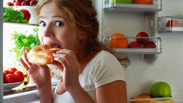 девушка ест из холодильника