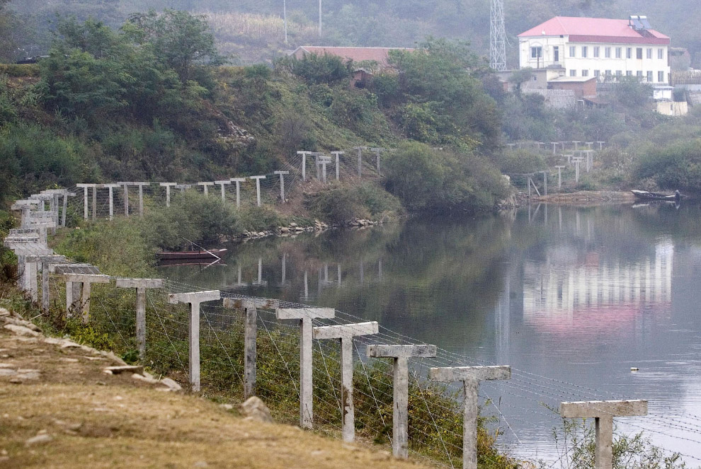Пограничный забор, отделяющий Северную Корею от города Даньдун на северо-востоке Китая