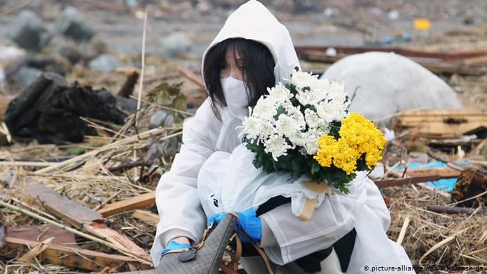 Женщина с цветами на зараженной территории около Фукусимы