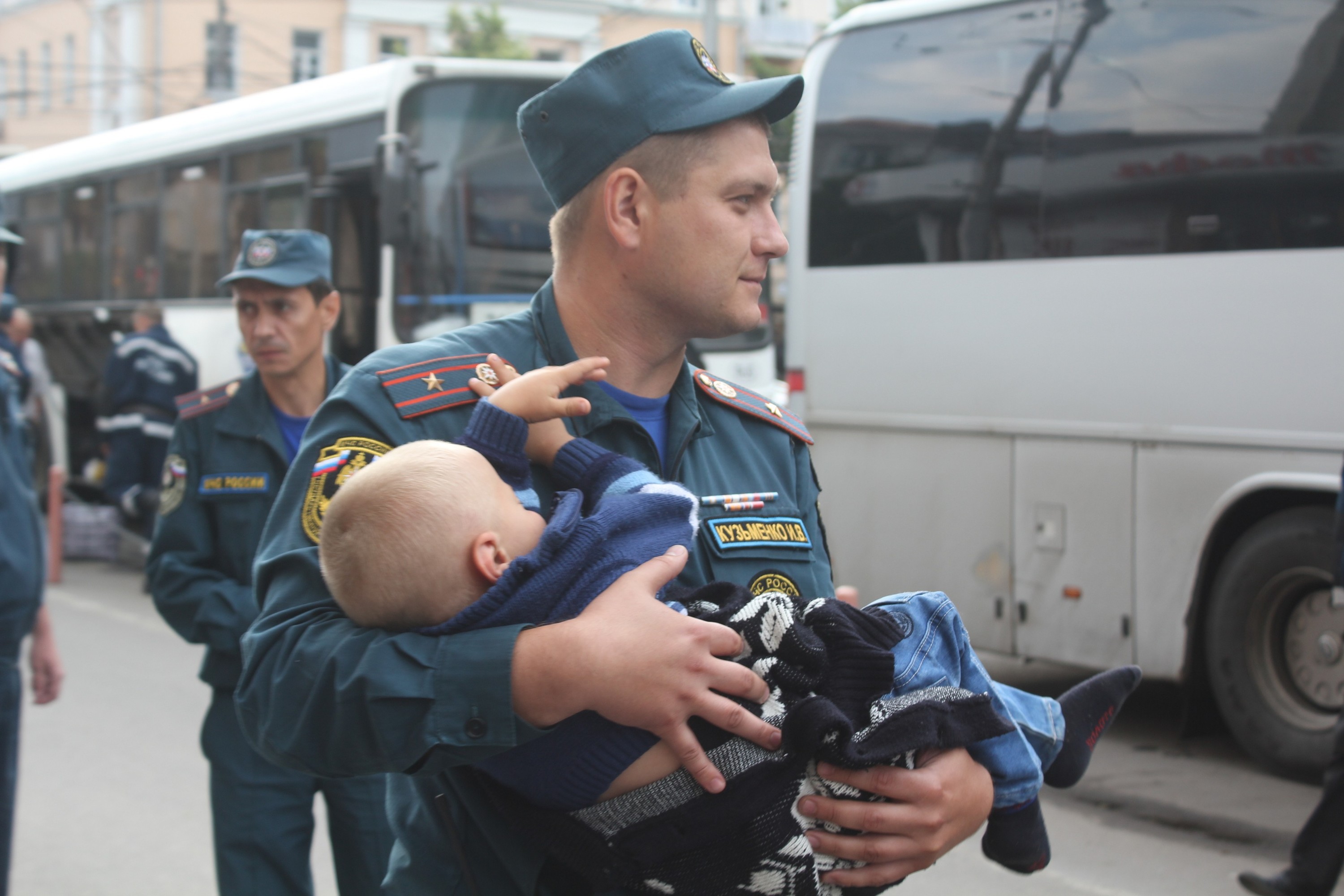 Спас человека. Полицейский спасает ребенка. Полицейский с ребенком на руках. Добрый полицейский. Полицейский помогает людям.