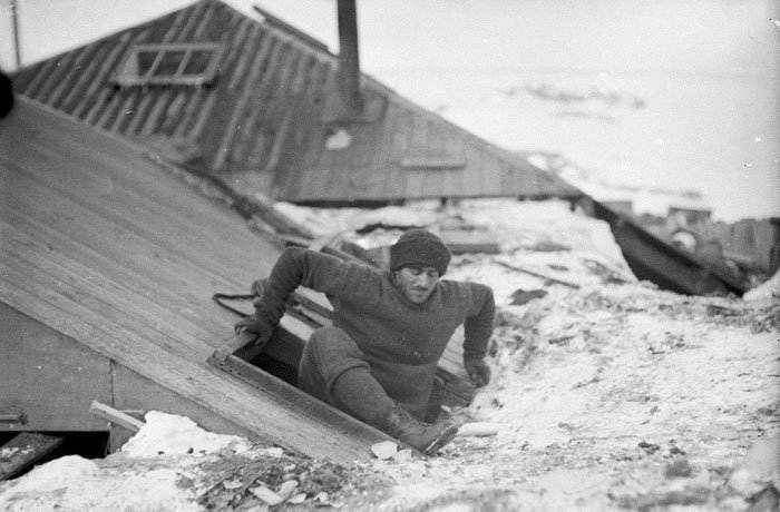 Ксавьер Мерц покидает засыпанный снегом дом через чердачное окно Дуглас Моусон, австралия, антарктида, изучение Антарктики, научная экспедиция, полярные исследователи, поход во льдах, фотосвидетельства
