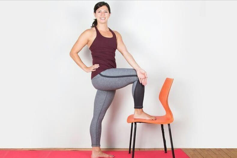 8 поз йоги. Женщина стоит на одной ноге. Поза одна нога на стуле. Стоять на одной ноге. Йога со стулом.