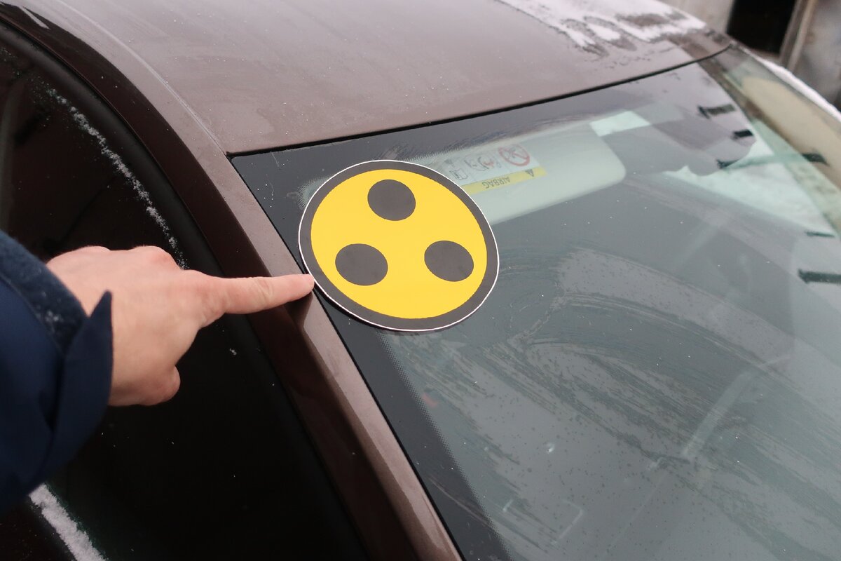 Три чёрных точки на жёлтом фоне в круге: Что означает этот знак, и кто должен его клеить на свою машину?