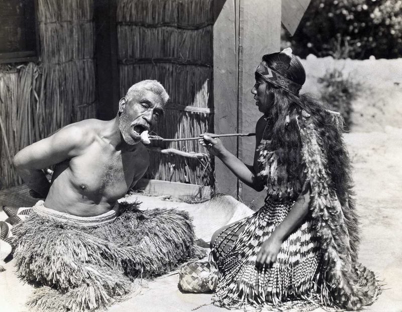 Врач и по совместительству шаман Маори кормит жителя Новой Зеландии, 1930 история, мгновения жизни, фотография