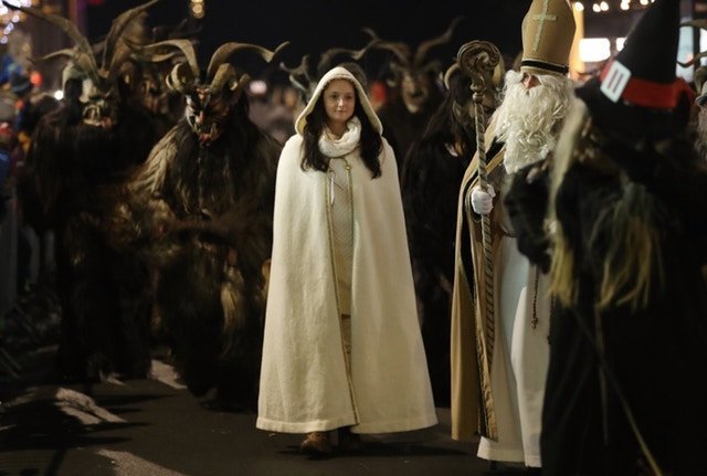Тем временем Святой Николай вместе с ангелом хвалят хороших детей австрия, крампус, мир, парад, праздник, фото, шествие