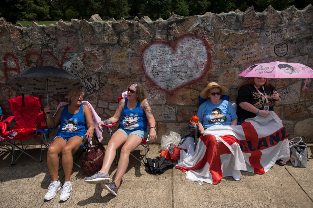Elvis fans, from left, Debby Twigg, Dustie Lundy, Ann Lawlor, and Lynn Lawlor wait in line outside Graceland, Elvis Presley's Memphis home, on Tuesday, Aug. 15, 2017, in Memphis, Tenn. Fans from around the world are at Graceland for the 40th anniversary of his death. Presley died Aug. 16, 1977.(AP Photo/Brandon Dill)