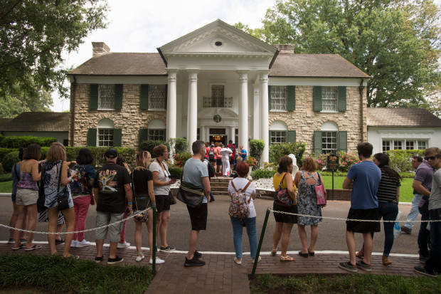 Fans wait in line outside Graceland, Elvis Presley's Memphis home, on Tuesday, Aug. 15, 2017, in Memphis, Tenn. Fans from around the world are at Graceland for the 40th anniversary of his death. Presley died Aug. 16, 1977.(AP Photo/Brandon Dill)