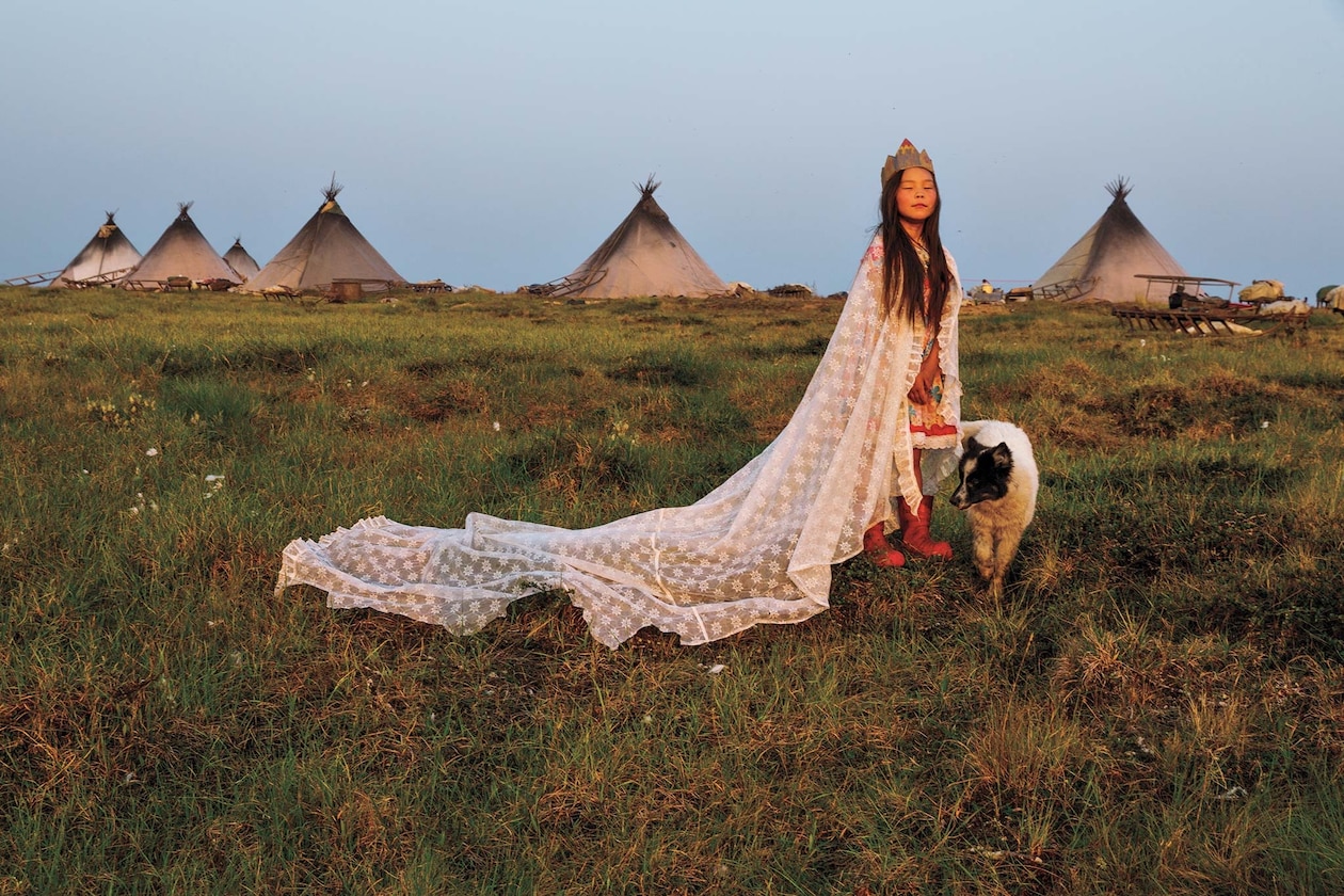Женщина в кружевной занавеске вместо халата и картонной короне перед лагерем коренных народов