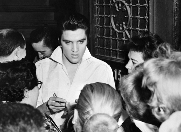 Rock 'n' roll legend Elvis Presley is surrounded by fans after a concert, in 1958. (Agence France-Presse via Getty Images)