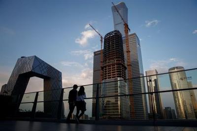 People look at the skyline of the Central Business District in Beijing, China, April 16, 2020. REUTERS/Thomas Peter