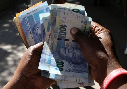 FILE PHOTO: A street money changer counts South African Rands in Harare, Zimbabwe, May 5, 2016. REUTERS/Philimon Bulawayo/File Photo