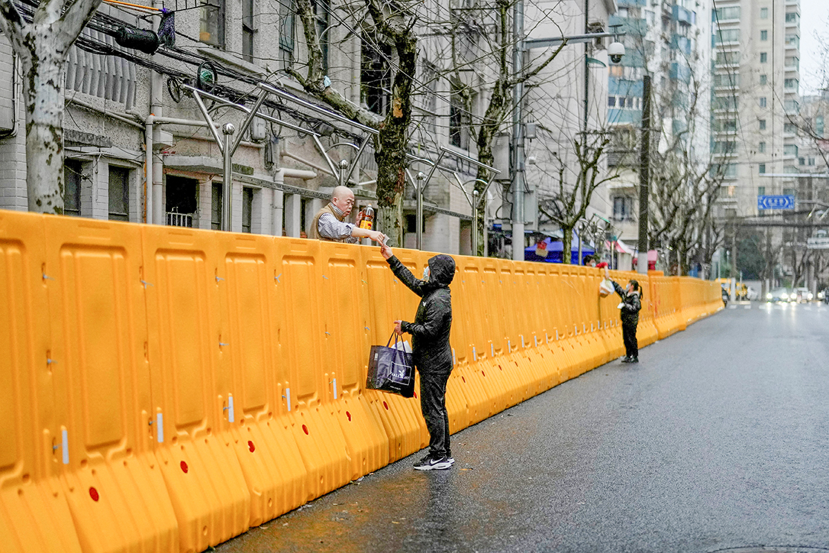 Курьеры передают заказы через ограждения 