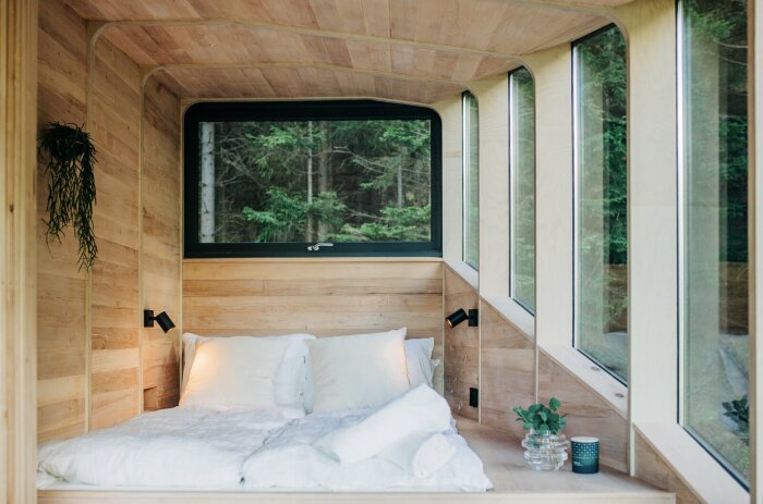 В основной спальне, помимо двуспальной кровати, созданы встроенные шкафы, которые замаскировали под деревянную обшивку (Woodnest, Норвегия). | Фото: dwell.com.