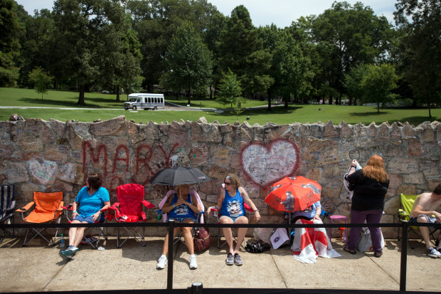 Fans wait in line outside Graceland, Elvis Presley's Memphis home, on Tuesday, Aug. 15, 2017, in Memphis, Tenn. Fans from around the world are at Graceland for the 40th anniversary of his death. Presley died Aug. 16, 1977.(AP Photo/Brandon Dill)