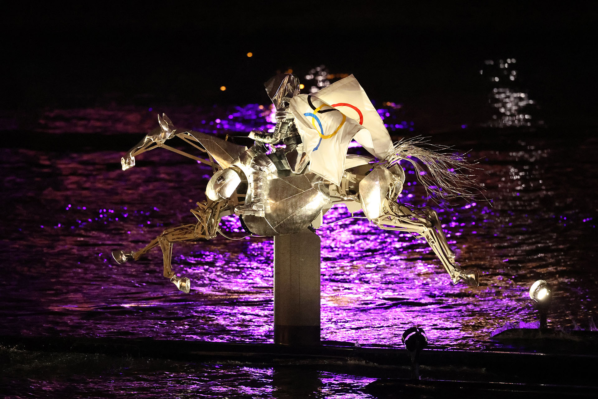 Металлический конь с олимпийским флагом на Сене во время открытия Олимпийских игр в Париже