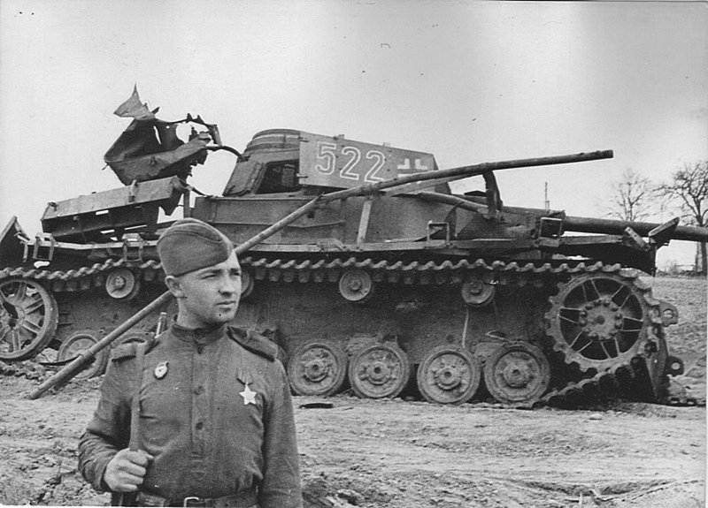 Советский солдат позирует на фоне немецкого среднего танка Pz.Kpfw.IV Ausf. J, уничтоженного на Украине. Великая Отечественная война, СССР, Солдаты моей страны