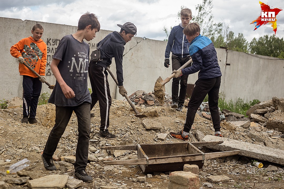 Подростки засыпают ямы строительным мусором, который привезли местные жители. Фото: Валентина ВАГАНОВА