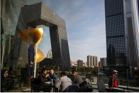 People eat lunch at a terrace restaurant near the CCTV building in the Central Business District (CBD) following an outbreak of the coronavirus disease (COVID-19) in Beijing, China, October 27, 2020. REUTERS/Thomas Peter