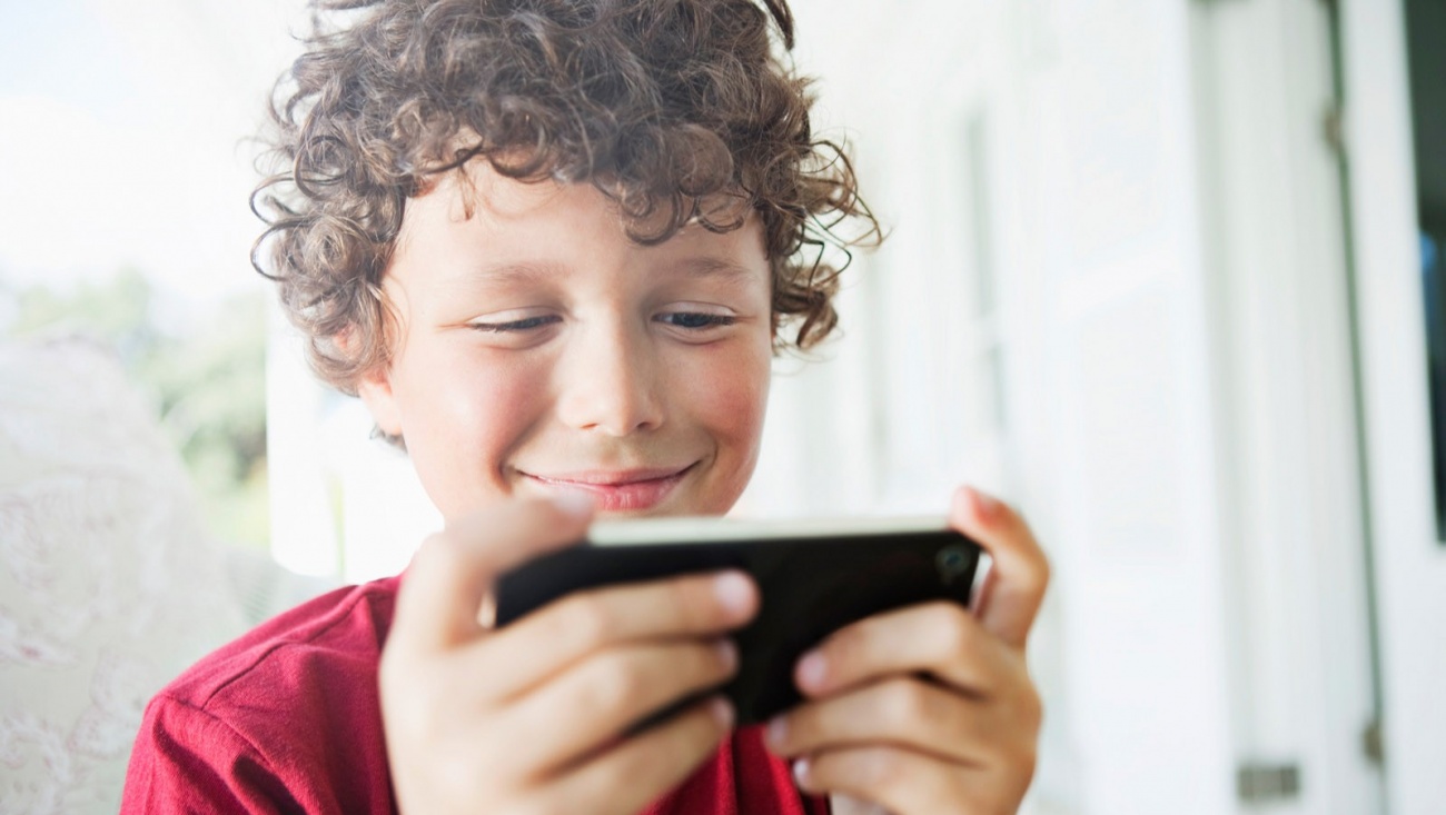 Фото ребенка с телефоном. Подросток с телефоном. Ребенок со смартфоном. Мальчик с телефоном. Человек играющий в телефон.