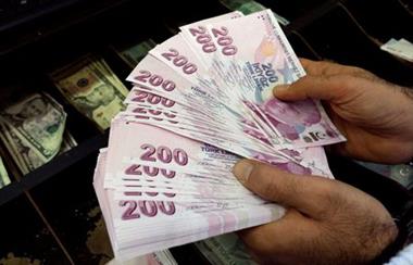 FILE PHOTO: A money changer counts Turkish lira bills at a currency exchange office in Istanbul, Turkey, December 16, 2014. REUTERS/Murad Sezer//File Photo