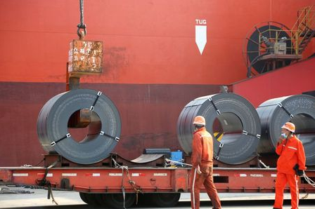 FILE PHOTO: Workers wearing face masks following the coronavirus disease (COVID-19) outbreak load steel products for export to a cargo ship at a port in Lianyungang, Jiangsu province, China May 27, 2020. China Daily via REUTERS /File Photo