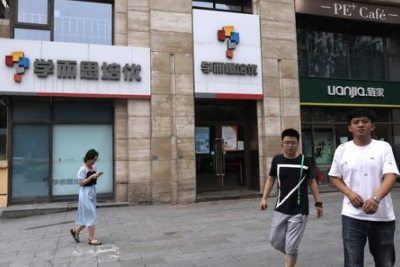 People walk past a Xueersi outlet, a private educational services provider owned by TAL Education Group, in Beijing, China July 26, 2021. REUTERS/Tingshu Wang