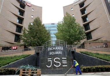 A worker sweeps in front of the Johannesburg Stock Exchange (JSE), in this picture taken March 23, 2016. Picture taken March 23, 2016. REUTERS/Philimon Bulawayo. 
