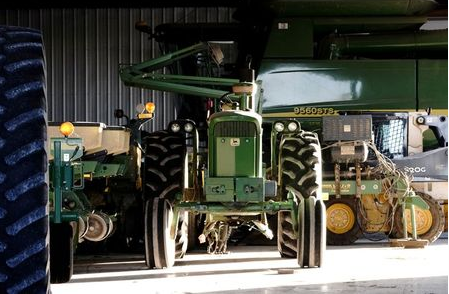 A John Deere tractor, a combine, and other heavy machinery sit inside a barn on a corn and soybean farm in Woodburn, Indiana, U.S., October 16, 2020. REUTERS/Bing Guan