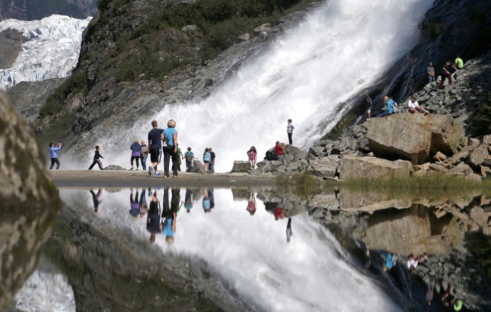 Туристы и их отражение на леднике Менденхолл.