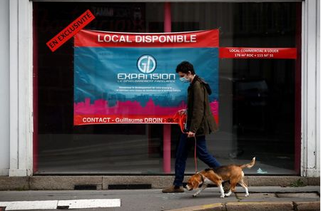 FILE PHOTO: A man walks his dog past a commercial space for rent in a street in Nantes, France, November 10, 2020. REUTERS/Stephane Mahe