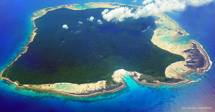 Вокруг Северного Сентинела коралловые рифы. Остров, кроме песчаного берега, покрыт тропическим лесом. Вид с борта самолета.