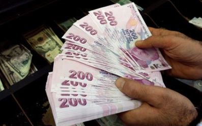 FILE PHOTO: A money changer counts Turkish lira bills at a currency exchange office in Istanbul, Turkey, December 16, 2014. REUTERS/Murad Sezer