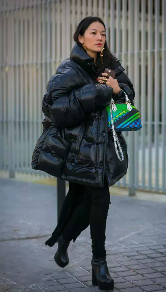 Девушка в черном пуховике и с яркой сумочкой