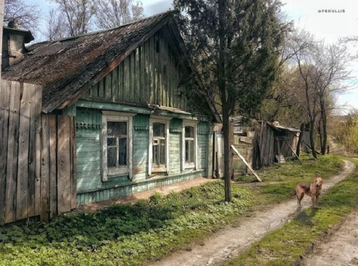 Деревенская дорога, проходящая практически под окнами деревянного дома.