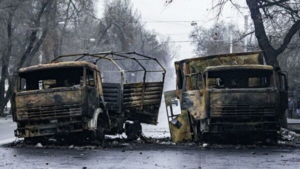 Сожженные грузовые автомобили на улице в Алма-Ате