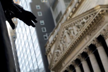 The hand of a sculpture of former U.S. President George Washington is pictured with the facade of the New York Stock Exchange (NYSE) building after the start of Thursday's trading session in Manhattan in New York City, New York, U.S., January 28, 2021. REUTERS/Mike Segar