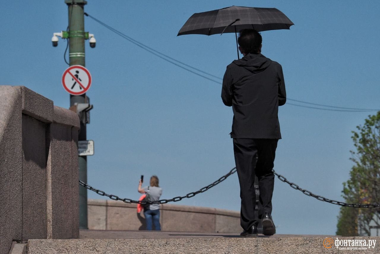 Петербуржцы прячутся от палящего солнца под зонтиками. В город пришла жара
