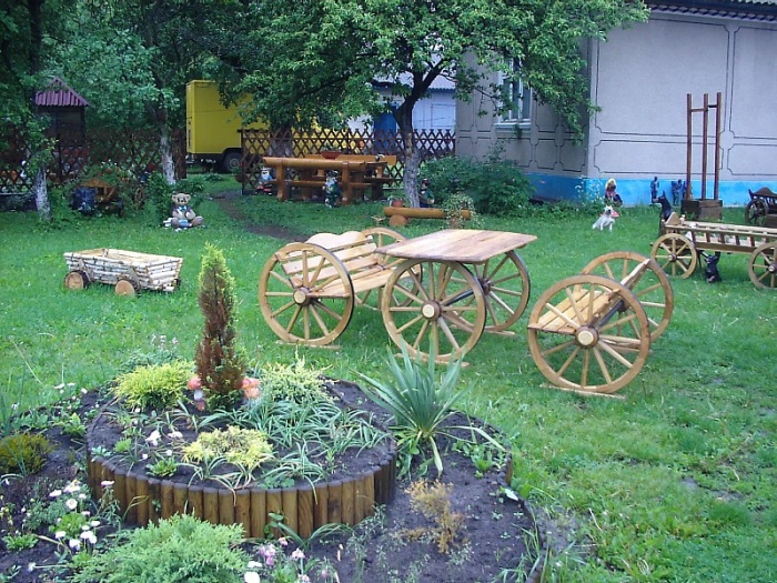 Уютные деревянные лавочки в стиле кантри на заднем дворе садового участка. 