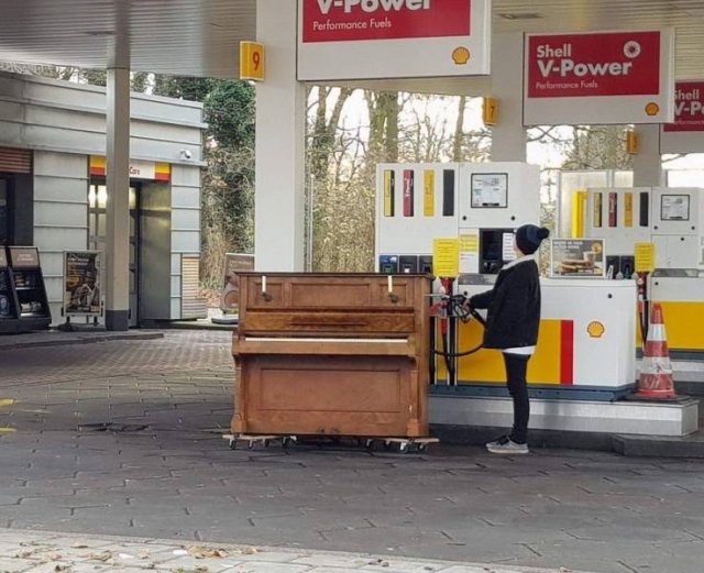 девушка заправляет бензином пианино на заправке