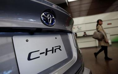 A woman walks past Toyota Motor Corp's C-HR model which is displayed at its headquarters in Tokyo, Japan, February 6, 2017. REUTERS/Kim Kyung-Hoon 