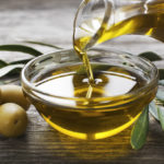 Оливковое масло наливают из бутылки в соусницу