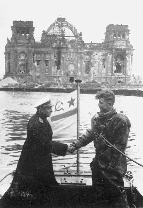 Контр-адмирал советского флота Иванович Крылов благодарит водолаза за расчистку реки Шпрее в центре Берлина  на фоне Рейхстага, в 1945 год