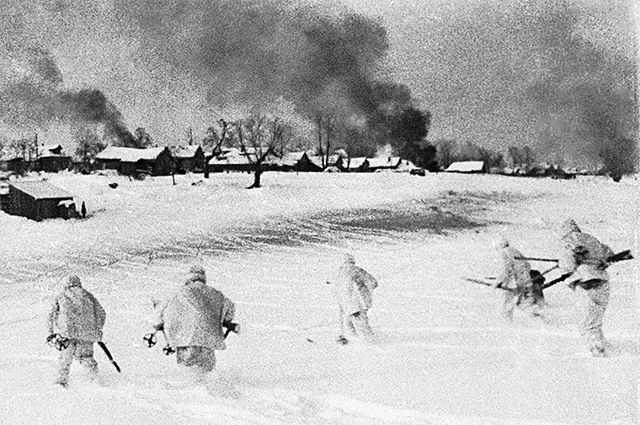 Контрнаступление советских войск в битве под Москвой (1941-1942). Бойцы в маскхалатах идут в атаку в подмосковной деревне, занятой немецко-фашистскими войсками. Кадр из документального фильма «Разгром немецко-фашистских войск под Москвой».