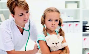 врач прослушивает ребенка фонендоскопом