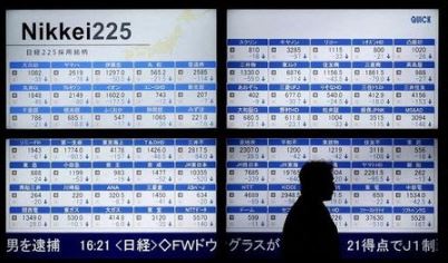 A man walks past an electronic board showing Japan's Nikkei 225 outside a brokerage in Tokyo, Japan January 12, 2016. Japan's Nikkei fell 2.7 percent after a market holiday on Monday, closing at its lowest in nearly a year, while U.S. stock mini futures were in the red pointing to a weak start. REUTERS/Toru Hanai