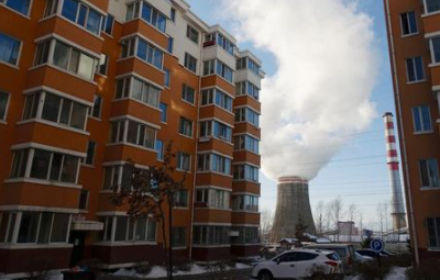 Smoke billows from a cooling tower of a thermal power plant near residential buildings in the coal city of Hegang, Heilongjiang province, northeast China January 2, 2020. Picture taken January 2, 2020. REUTERS/Ryan Woo